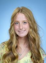 Professional headshot of Emry Ottmer, with long curly blonde hair wearing a yellow floral shirt