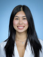 Professional headshot of Gloria Huynh with long dark hair, wearing a white coat over a white top