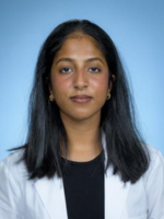 professional headshot of Judith Jose with medium length dark hair, wearing a whitecoat over a black top
