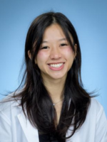 Professional headshot of Michelle Tran with long black hair, wearing a whitecoat, in front of a blue background