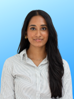 Professional headshot of Sivitmika Palanisami with long black hair, wearing a striped shirt in front of a bright blue background