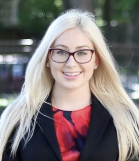 photo of caucasian woman wearing glasses and professional dress, smiling outdoors