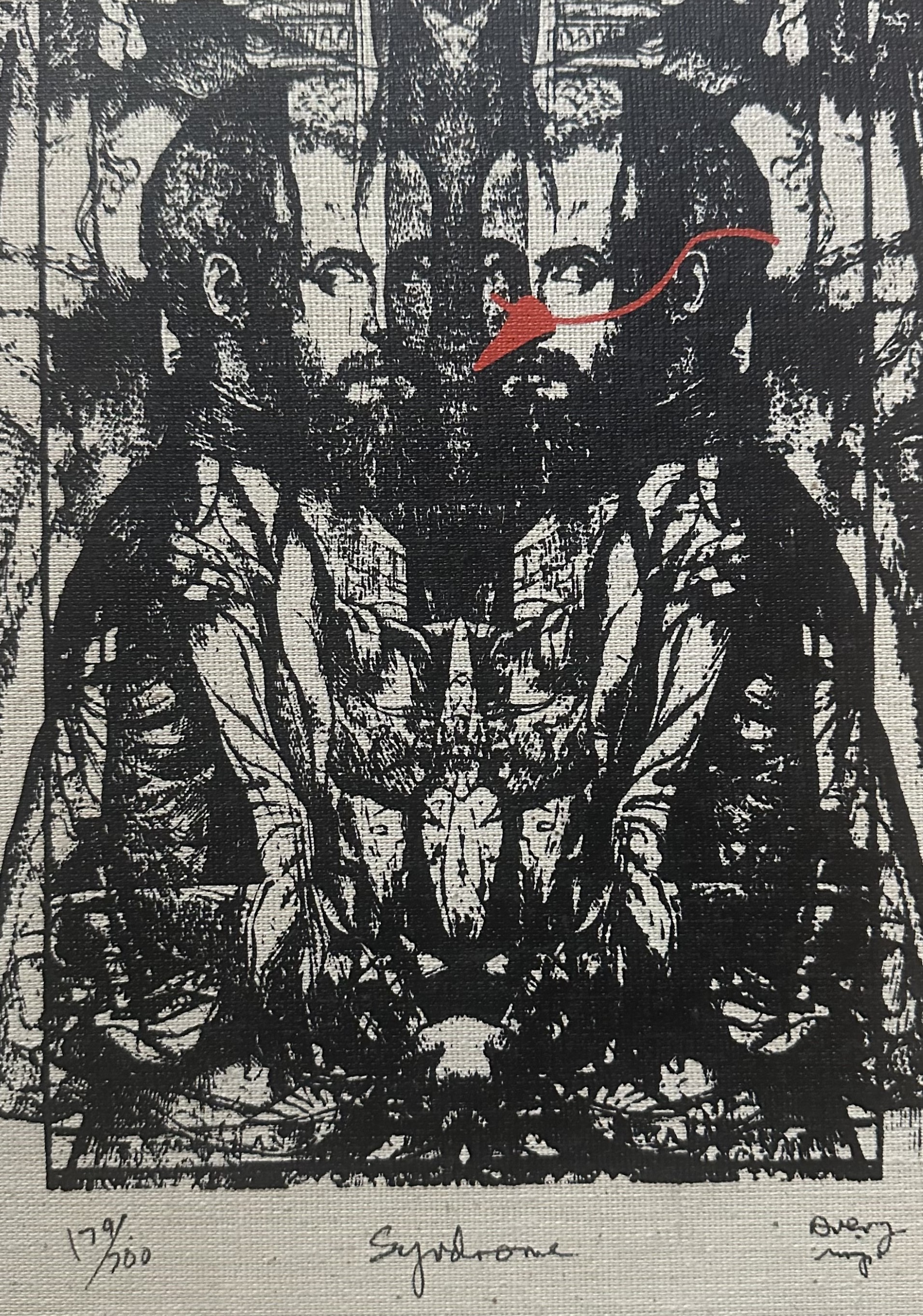 Black block print on a white fabric background. Double image of a man (face to face). Figure on right wearing a red pointed nose cone.