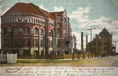 Foreground (left) color tinted (red/orange) photograph of the three-story ornate building. Another building is to the right.