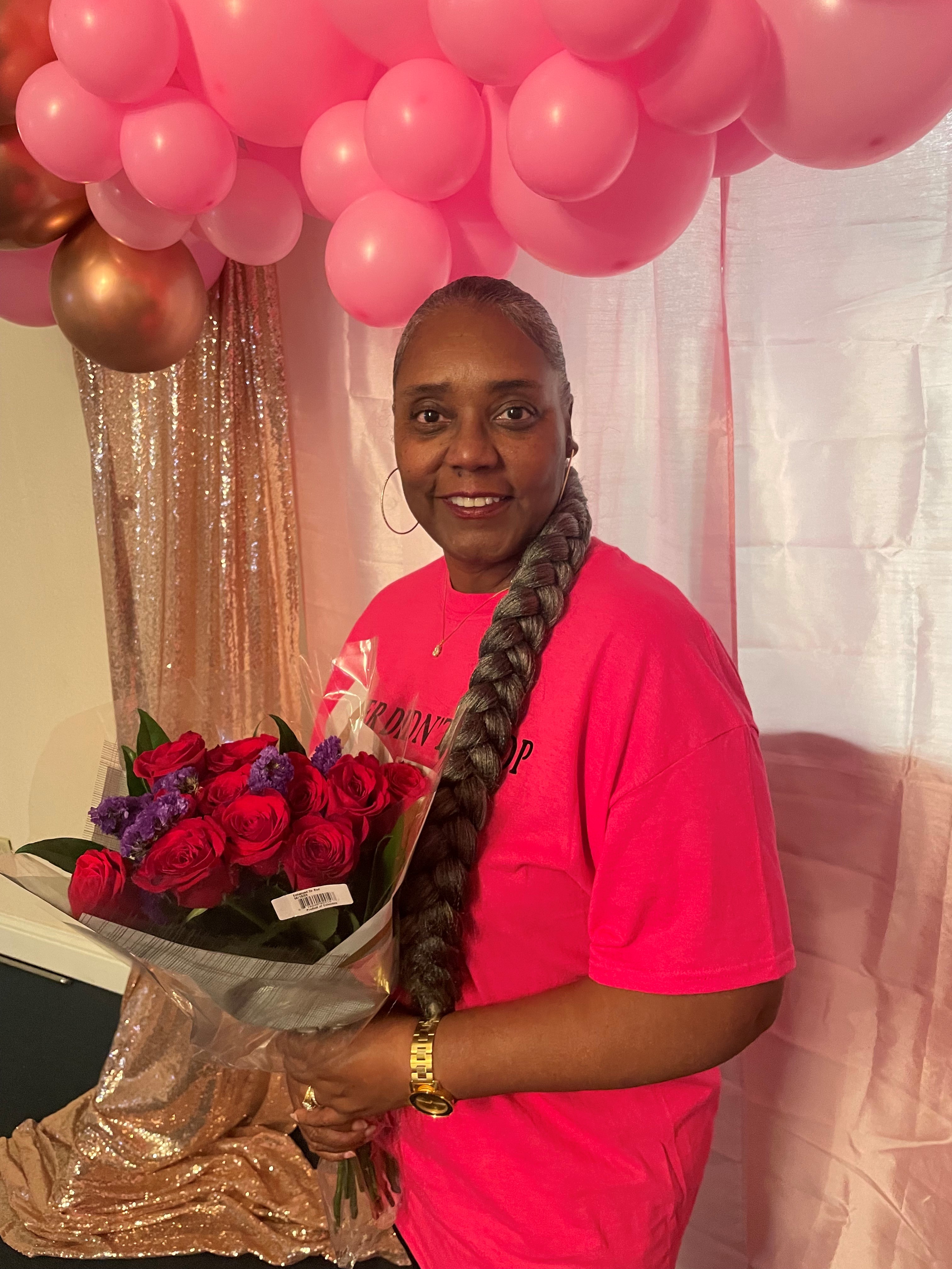 image of breast cancer survivor Glory Childs holding bouquet of flowers