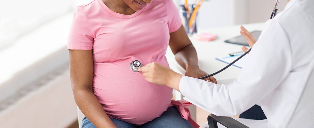 pregnant woman getting baby checked with stethoscope