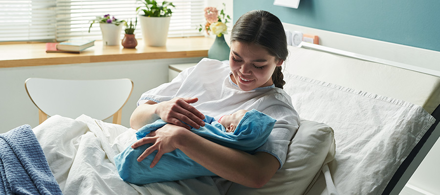 A mother holds her newborn baby in a postpartum room at UTMB Health Labor and Delivery in Galveston.