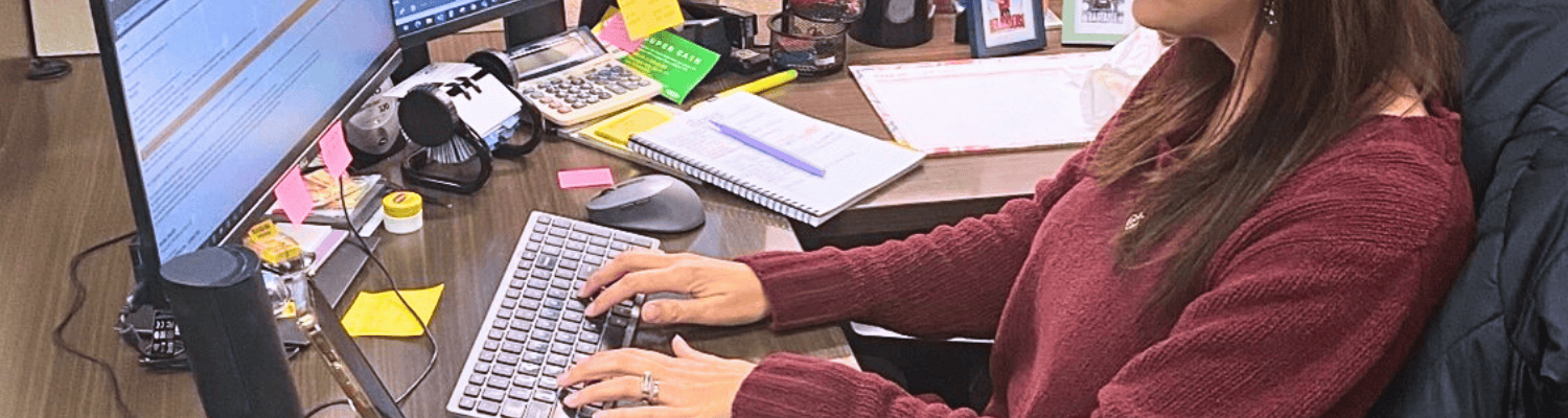 Female sitting on office chair typing on her work computer