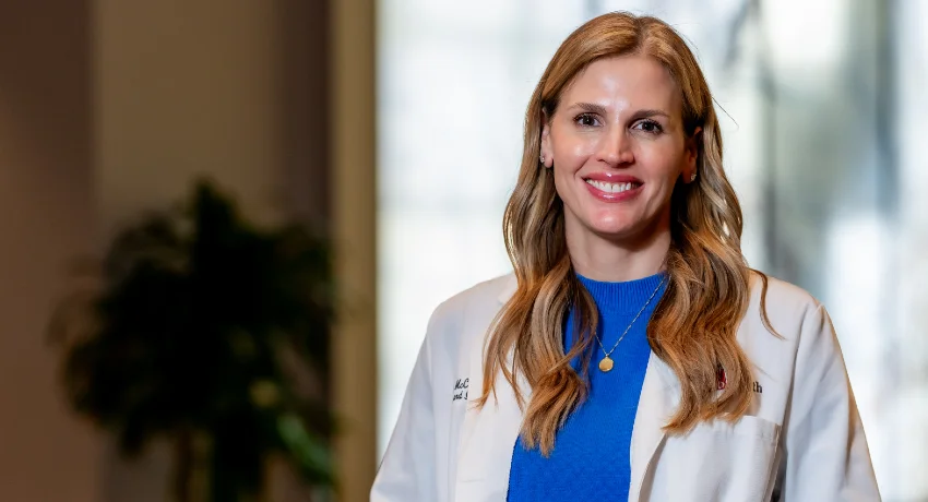 Jennifer McCracken, MD, UTMB allergist and immunologist, wearing a white medical coat over a blue blouse.