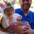 Doc holding baby in unicorn costume