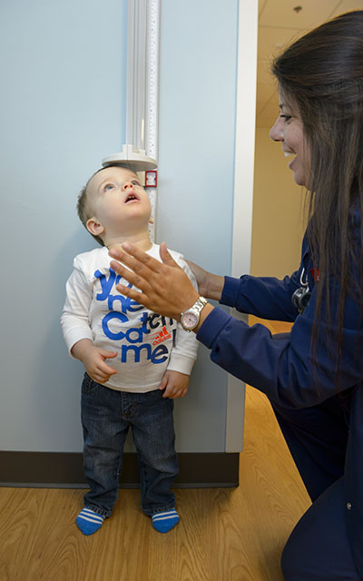 small boy getting measured by lady