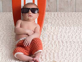 Baby sunning on lounge chair on carpet