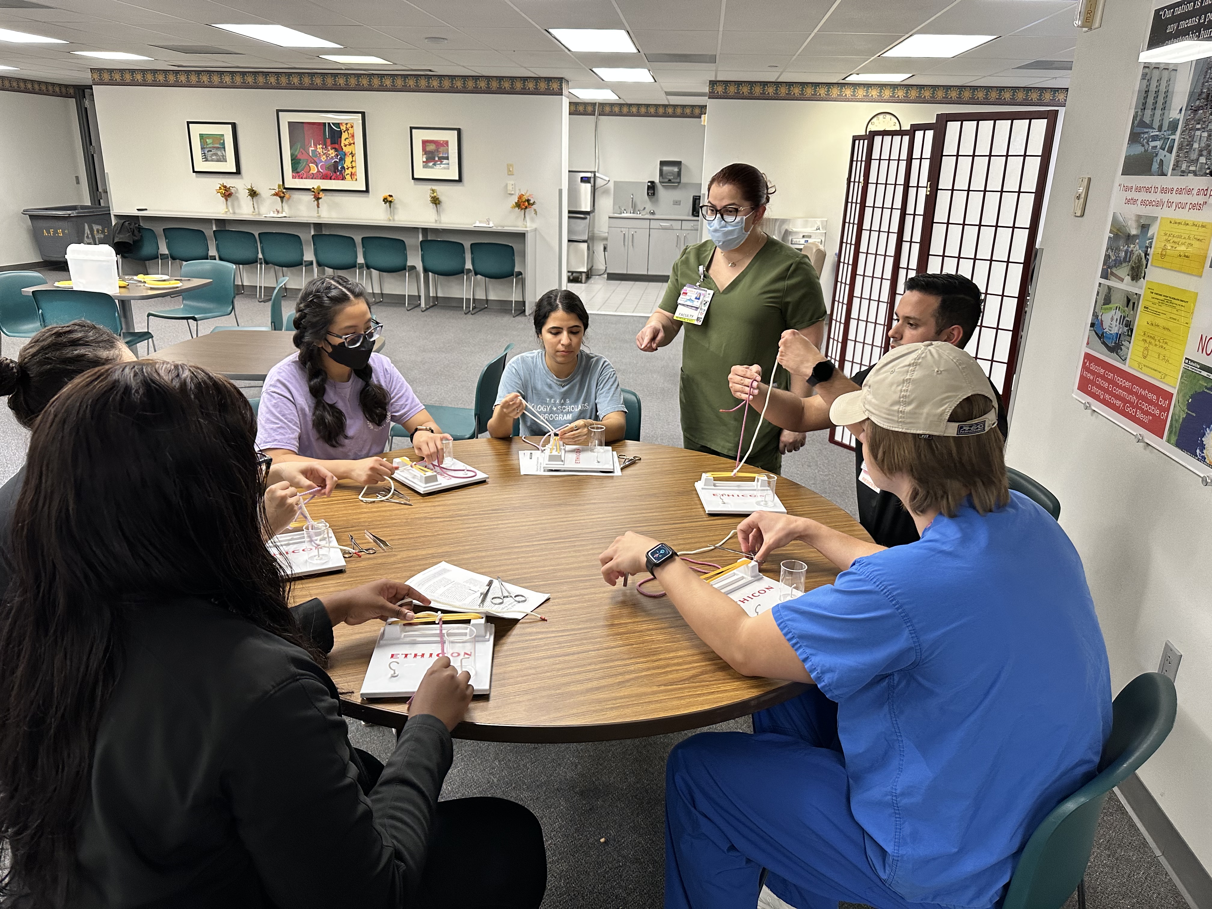 Photo of Dr. Santiago Delgado teaching medical students knot tying