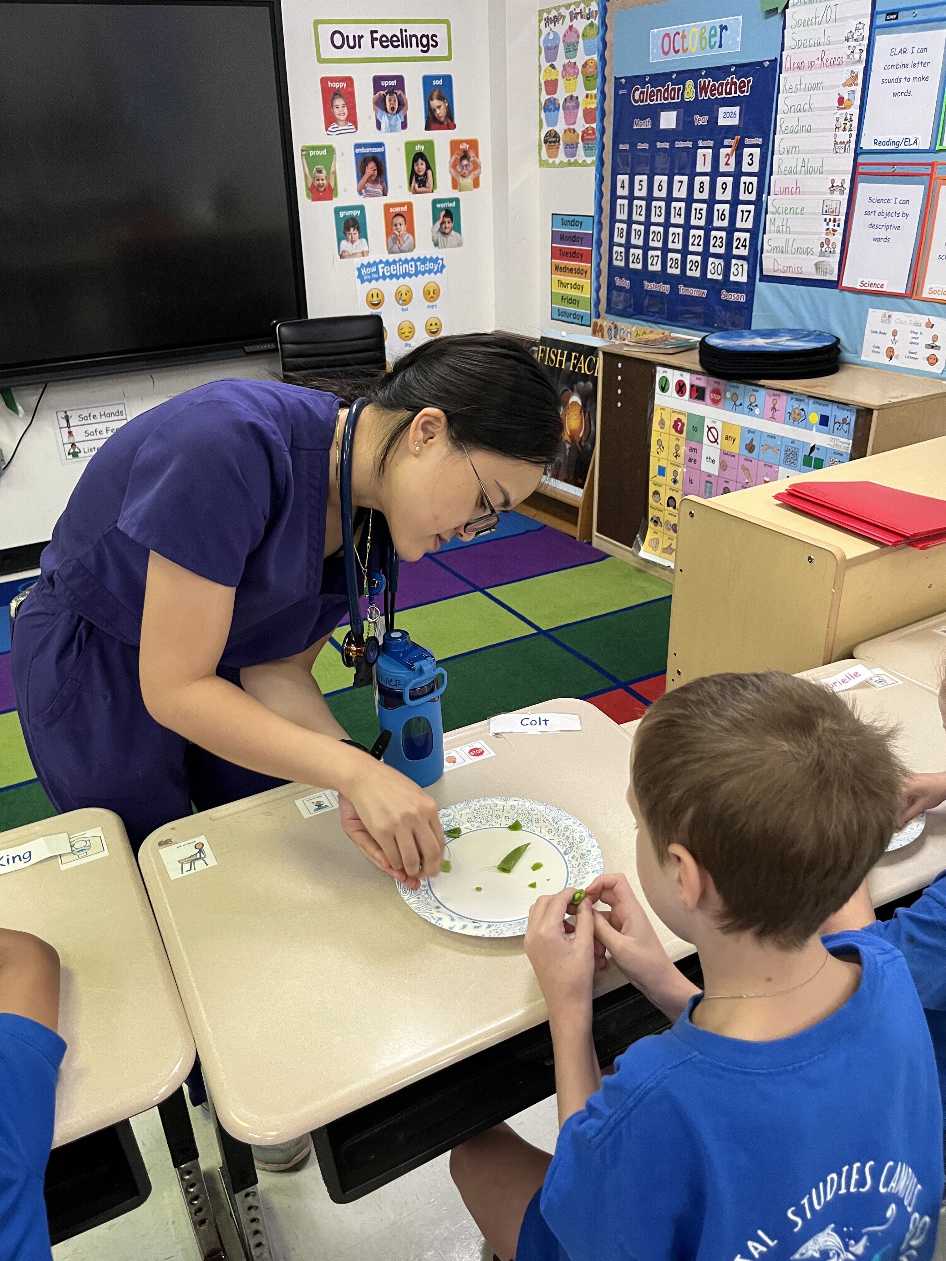 Photo of PGY-1 resident Ivy Nguyen working with students a Oppe Elementary as part of the Smart Literacy Life Skills Classes