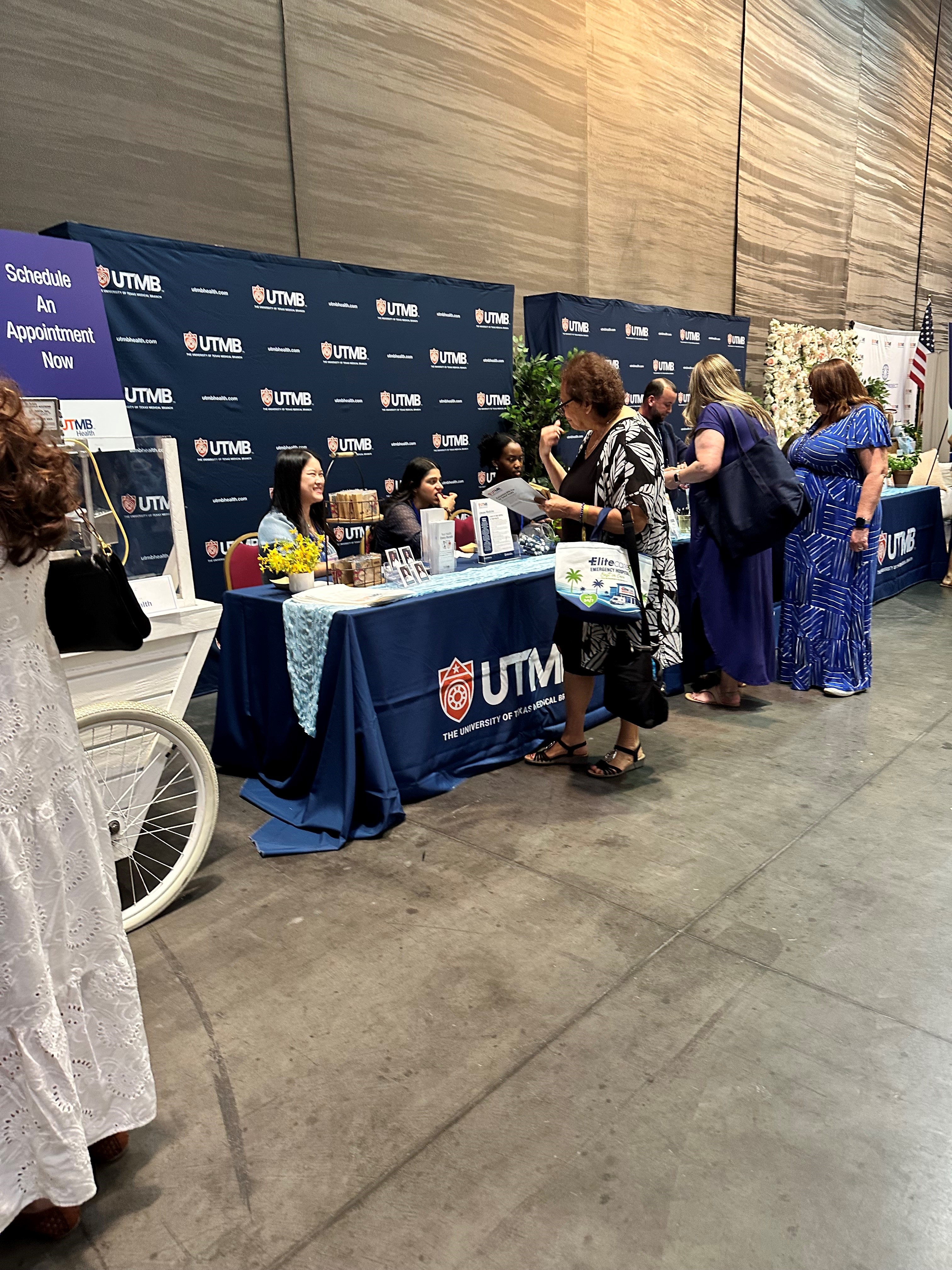 Photo of 3 Family Medicine Residents talking to a patient at the Galveston Women's Conference