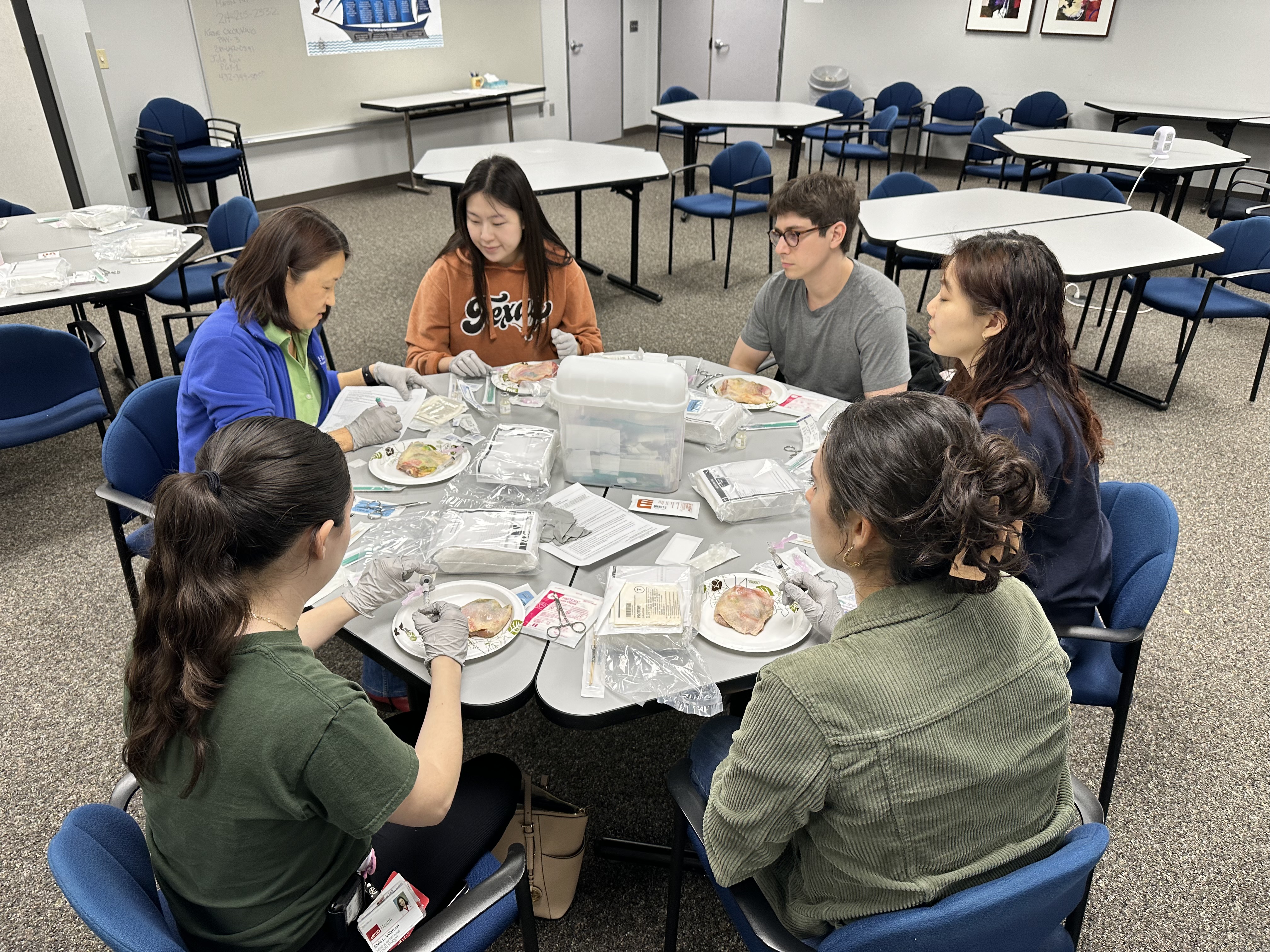 Photo of Dr. Kyu Jana teaching medical students suturing