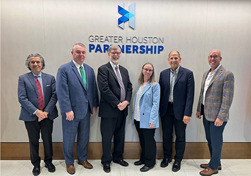 Five men and one woman-- leadership and representatives from TSU, UHCL, UTMB, Houston Methodist and the Greater Houston Partnership-- pose for a photo beneath a Greater Houston Partnership sign. See bottom of story for details.
