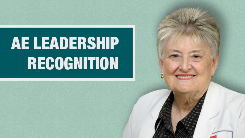 Graphic with a light teal background showing a person in a white lab coat beside a dark teal box containing the text ‘New AE Leadership Recognition.’