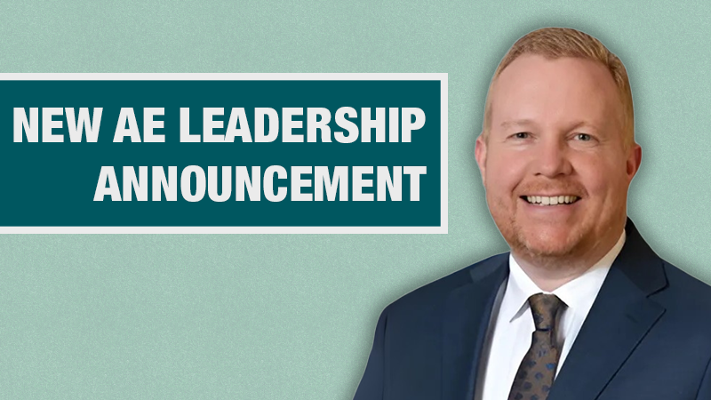 Graphic with a light teal background showing a person in a navy blazer beside a dark teal box containing the text ‘New AE Leadership Announcement.’