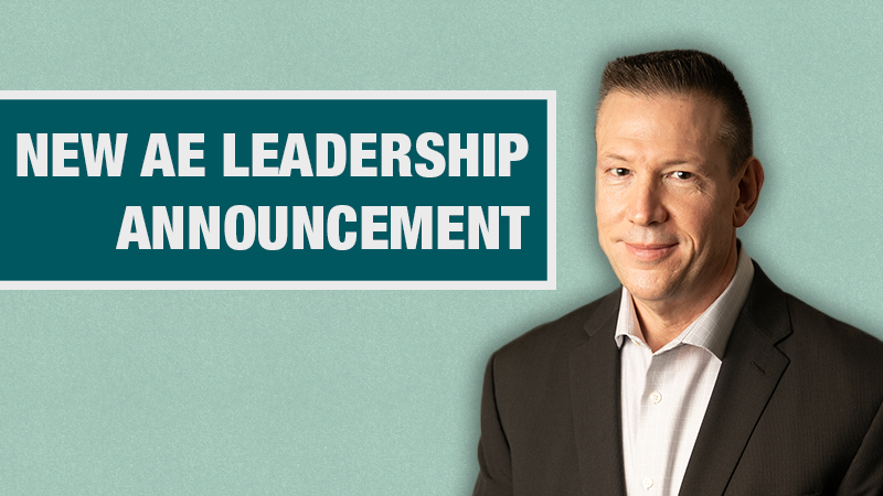 Graphic with a light teal background showing a person in a black blazer beside a dark teal box containing the text ‘New AE Leadership Announcement.’