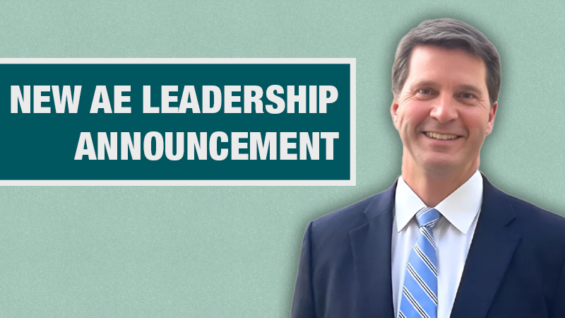 Graphic with a light teal background showing a person in a navy blazer beside a dark teal box containing the text ‘New AE Leadership Announcement.’
