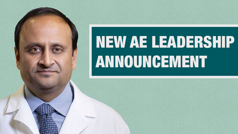Graphic with a light teal background showing a person in a white lab coat beside a dark teal box containing the text ‘New AE Leadership Announcement.’