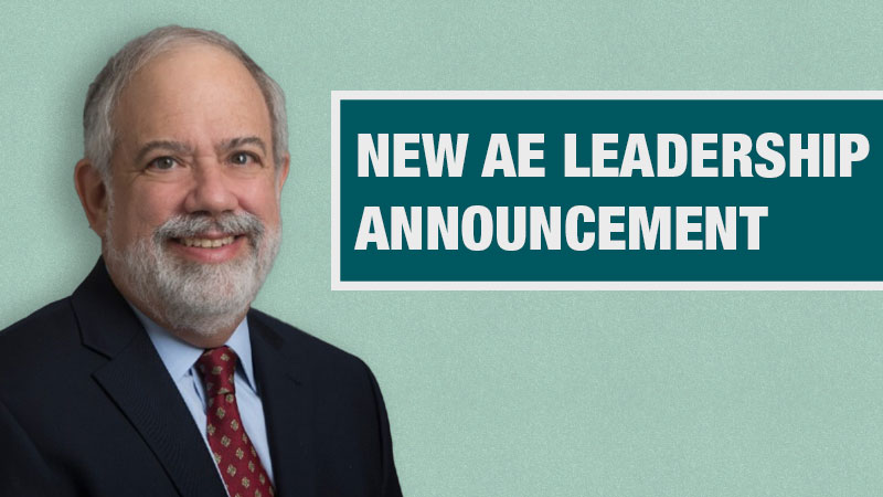 Graphic with a light teal background showing a person in a black blazer beside a dark teal box containing the text ‘New AE Leadership Announcement.’