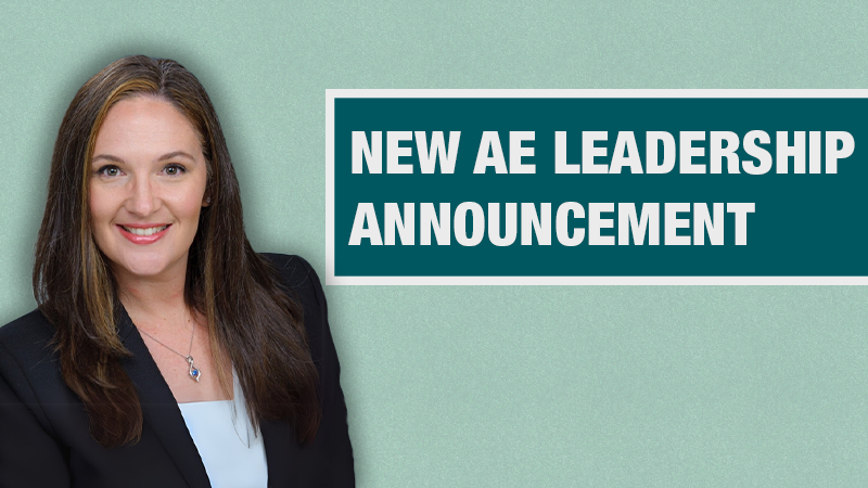 Graphic with a light teal background showing a person in a black blazer beside a dark teal box containing the text ‘New AE Leadership Announcement.’