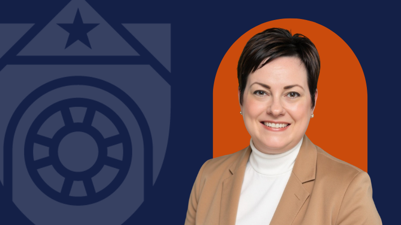 A woman in a tan blazer on a navy background with an orange backdrop behind her and the UTMB logo to the left.