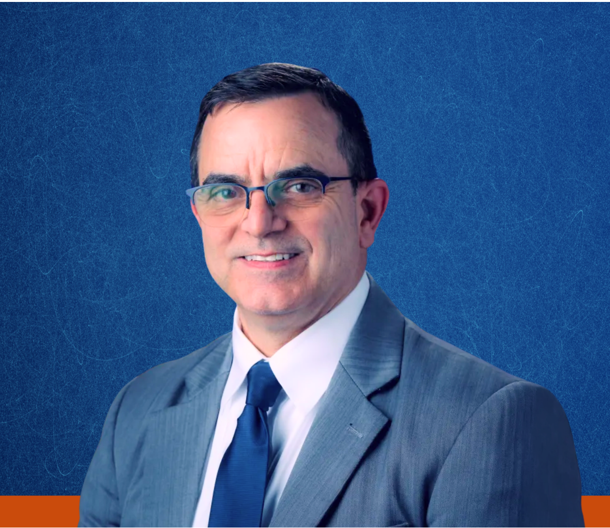 Portrait of Dr. J.D. Polk against a textured blue background and orange banner running across the bottom of the page