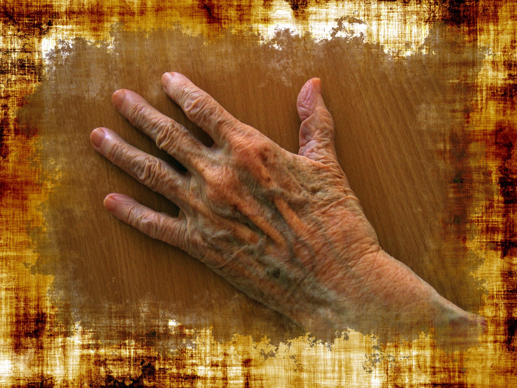 hand of older Caucasian on wooden table