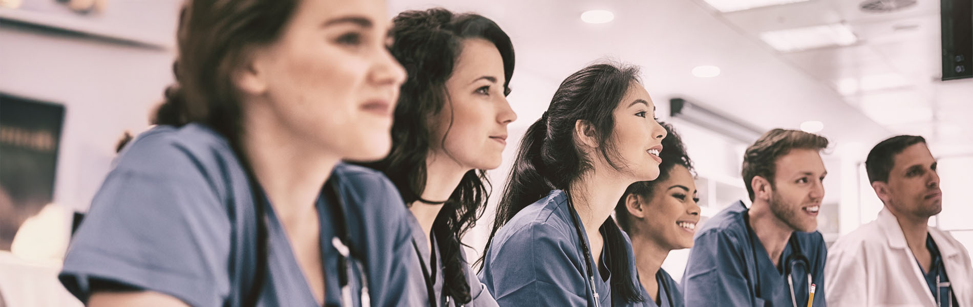Medical students listening sitting at desk