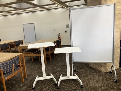 Photograph of rolling whiteboard and movable standing desks
