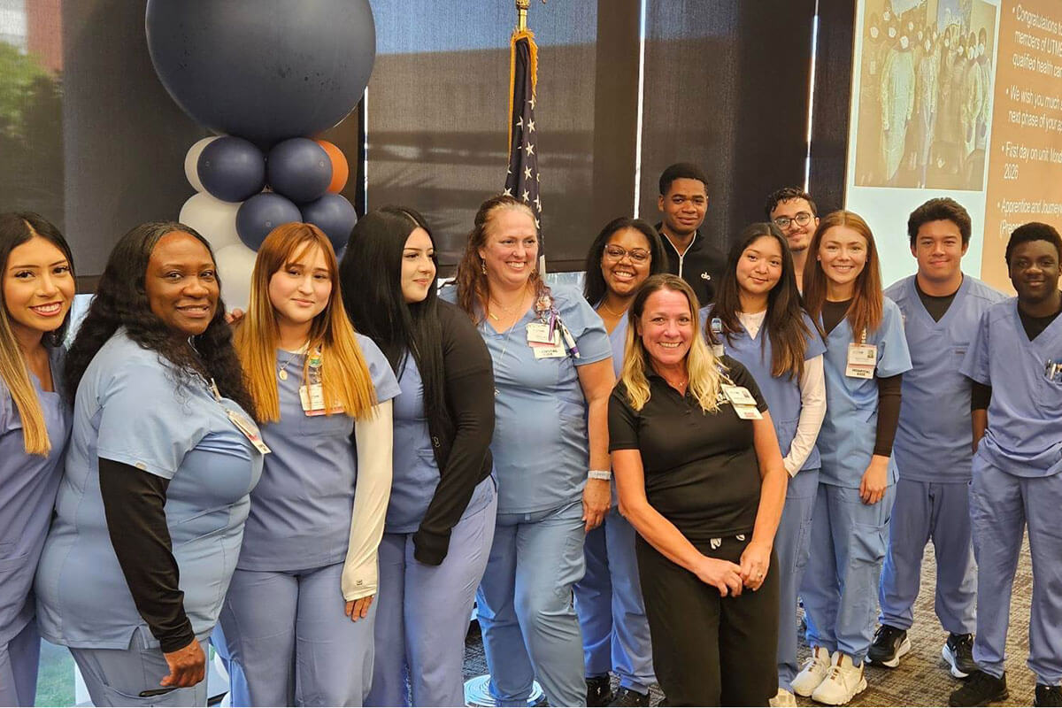 Group photo of CNA program graduates smiling together in Levin Hall.