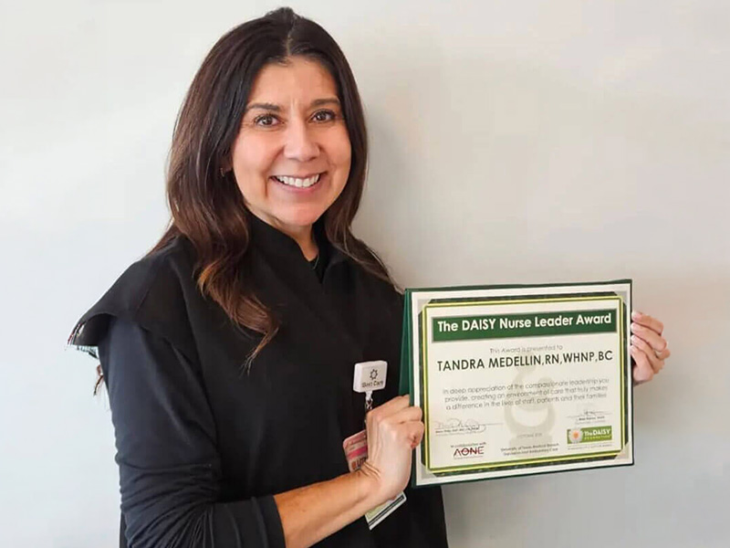 DAISY Nurse Leader Award recipient, Tandra Medellin, smiles holding her certificate.
