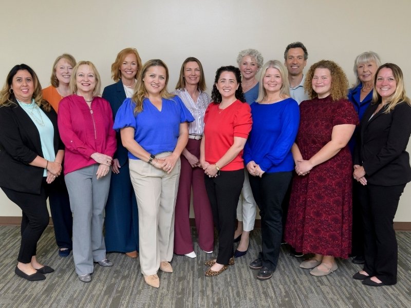 The NEAR team stands together smiling inside Jennie Sealy Hospital.