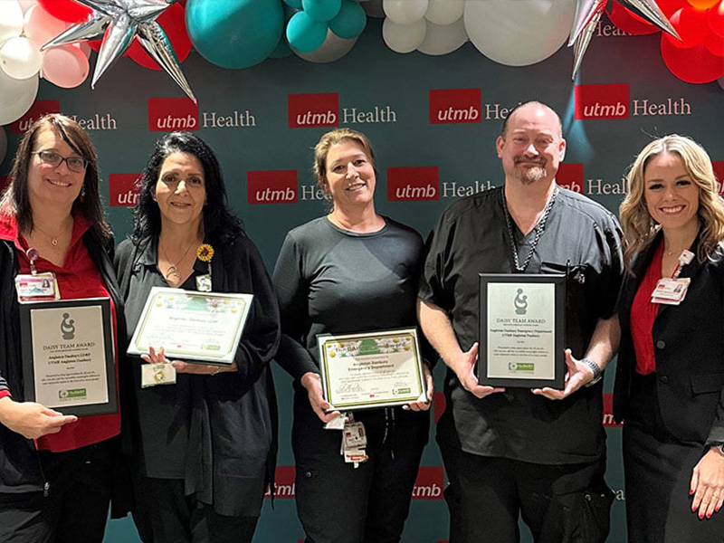 2024 DAISY Team Award recipients pose for a group photo holding their certificates.