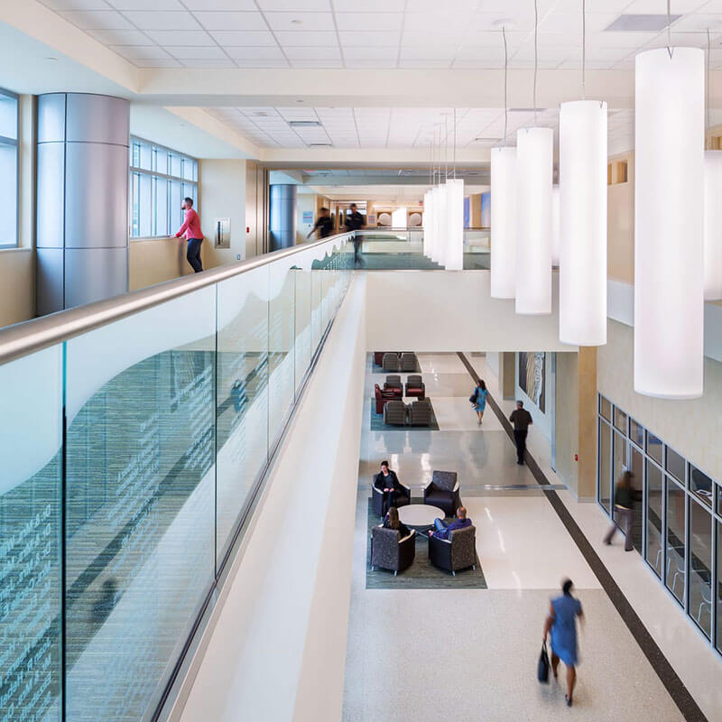A bright hallway showing hospital workers and people walking through Jennie Sealy Hospital.
