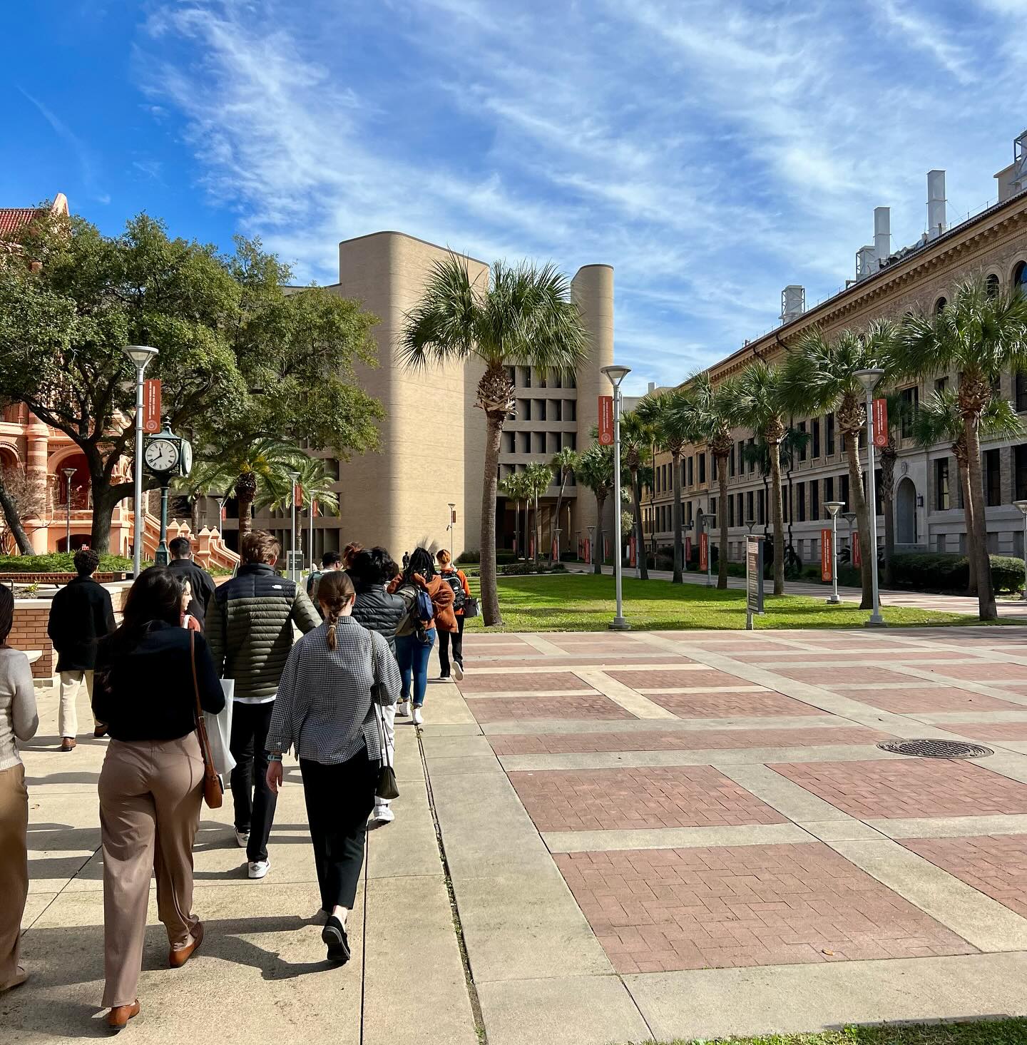 Group of people walking the UTMB Campus on a sunny day