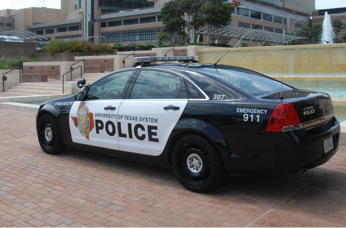 Black and white patrol care with the University of Texas System Police text on the doors parked on the UTMB campus