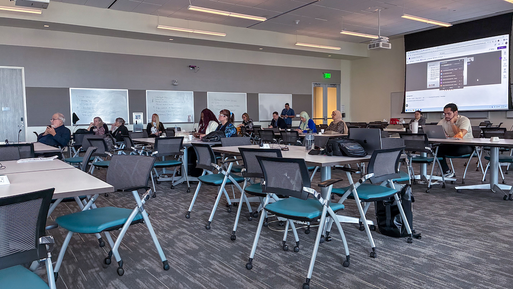 Badya at PHS 2026 - audience Wide view of attendees seated in a classroom during the Badya University poster session, with a presentation projected on a large screen at the front of the room.