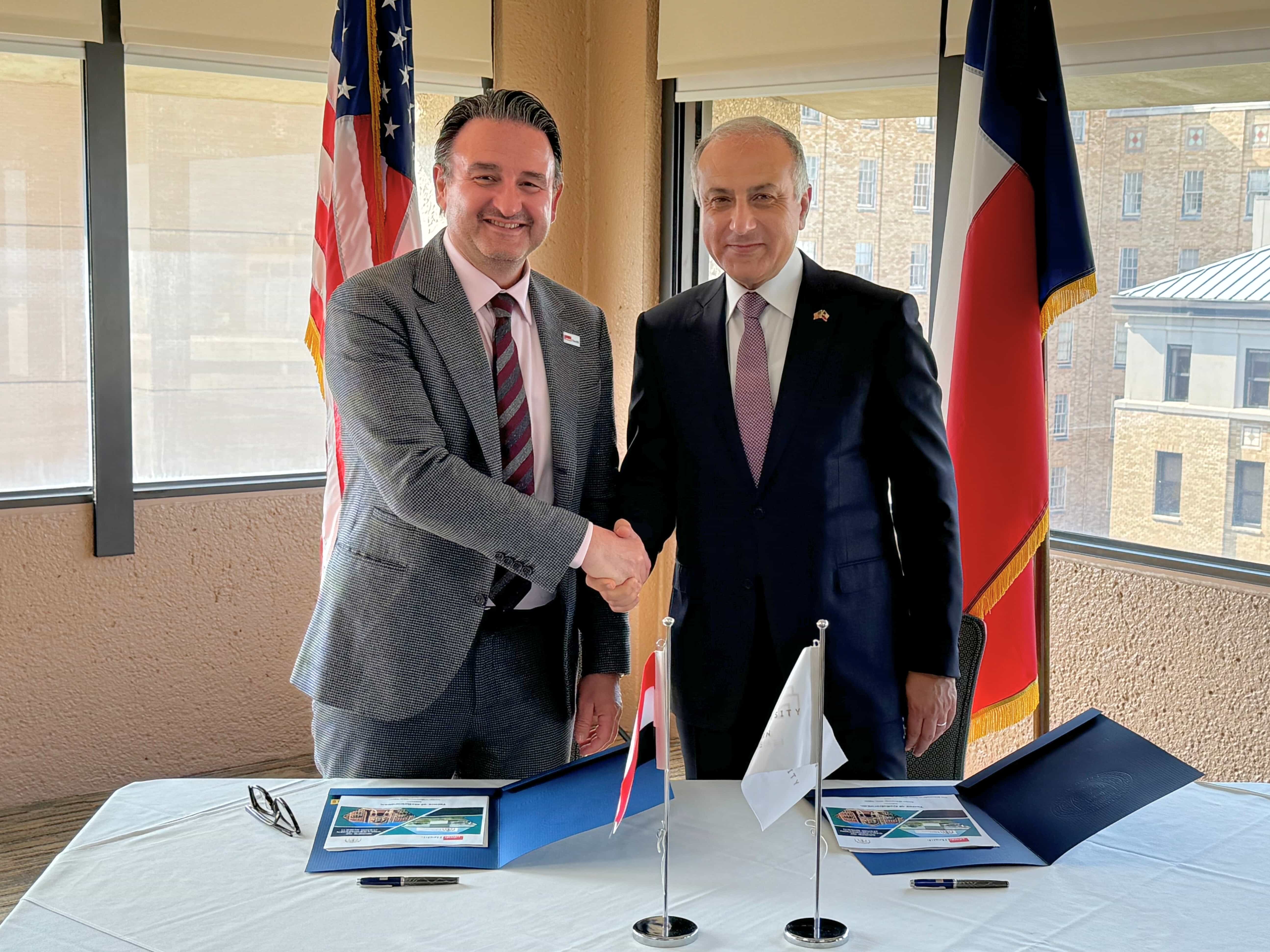 Dr. Reiser and Dr. Mallahy shaking hands after signing the collaboration agreement.