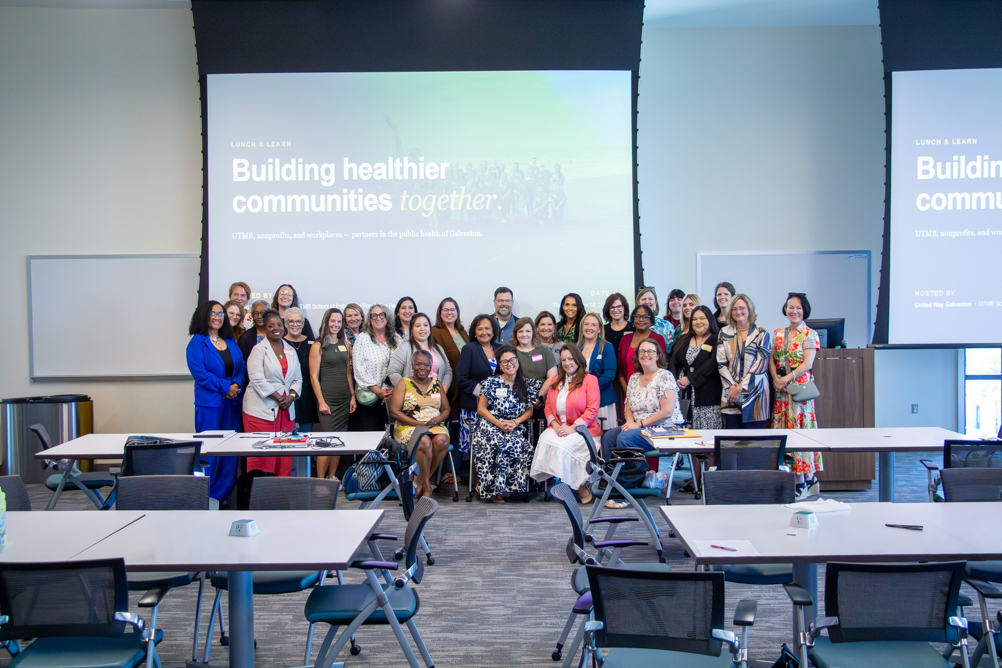 United Way Lunch and Learn participants pose for a group photo in front of the presentation screen.