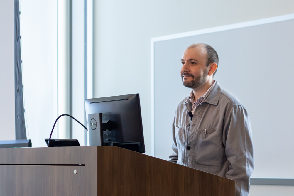 Dr. Jacob Moses delivers a seminar from a lectern in a UTMB classroom.