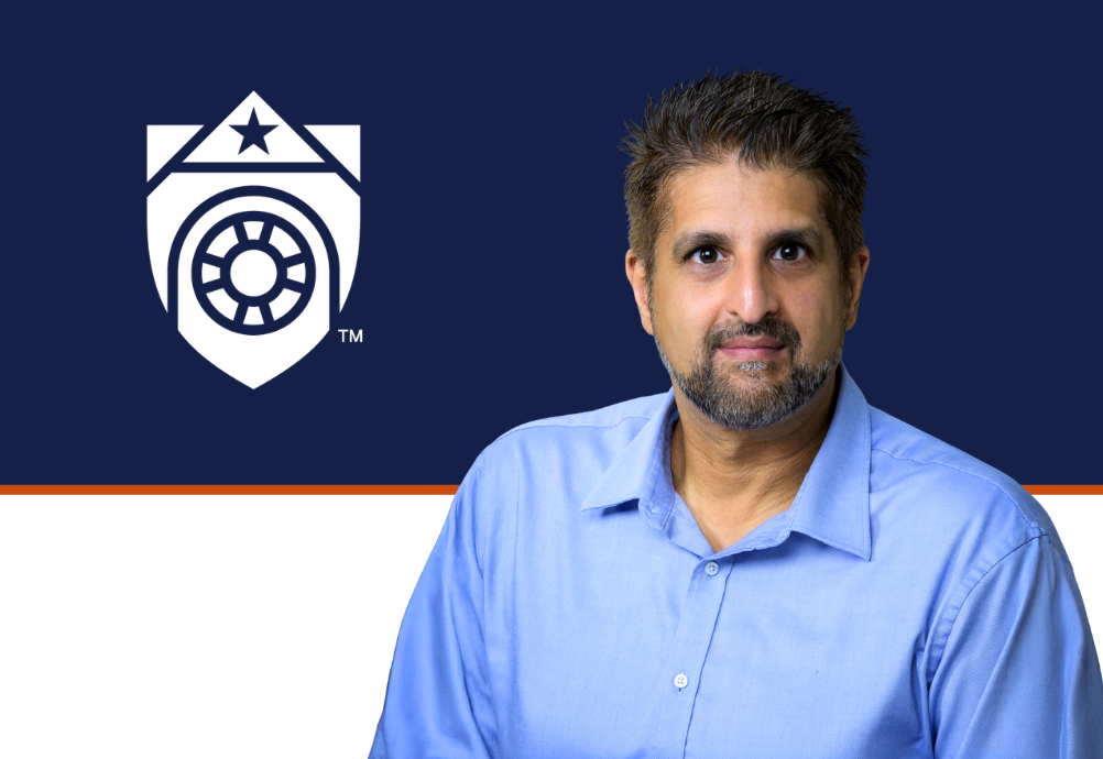 Neil Mehta, wearing a light blue shirt, beside the white UTMB shield on a navy-and-white background with an orange dividing line.