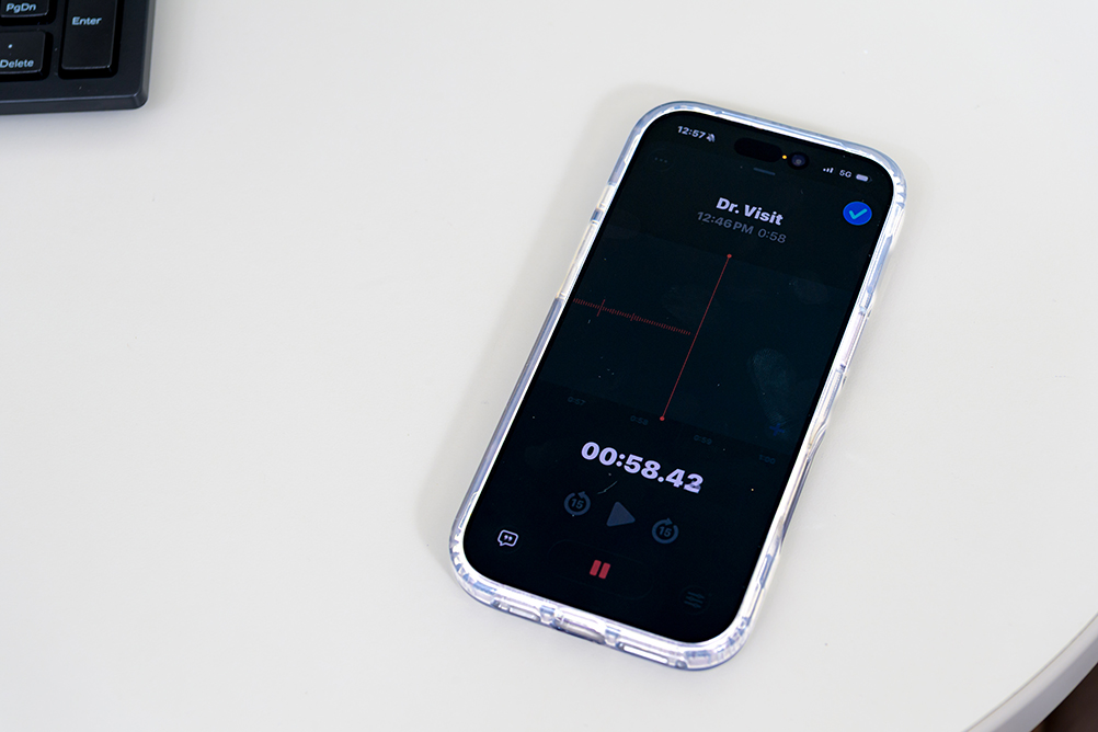 meredithmaselpressrewind2 A smartphone on a desk beside a keyboard, recording a voice memo labeled Dr. Visit at 58 seconds in the phone's audio app.