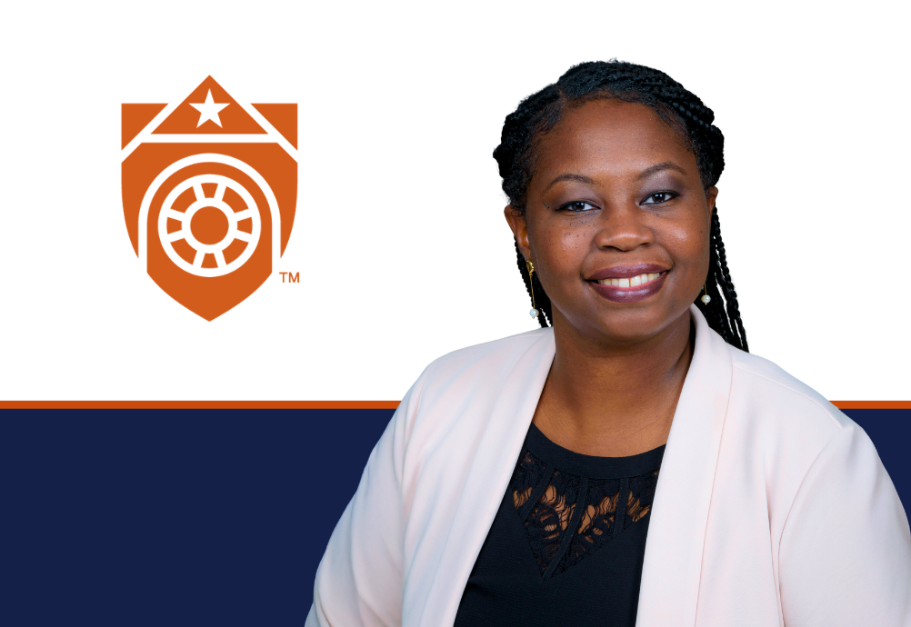 Dr. Monique Pappadis smiles in a light blazer beside the orange UTMB shield, with a navy and orange graphic band across the lower background.