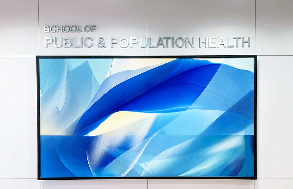 Interior wall display reading “School of Public & Population Health” above a large blue abstract artwork