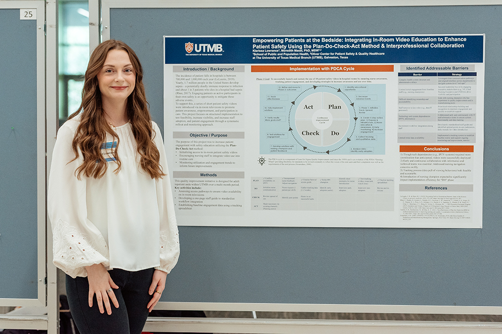 An MPH student poses with her poster presentation