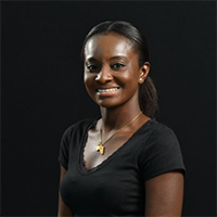 Portrait of Rebecca Anumel-Ackah smiling against a dark background.